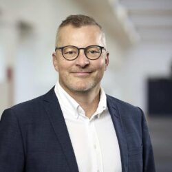 Portræt af Torsten Bielefeldt Schlägelberger, CEO for Conscensia, ledsaget af citat om at bygge bro mellem mennesker, kulturer og forretninger gennem nearshoring.